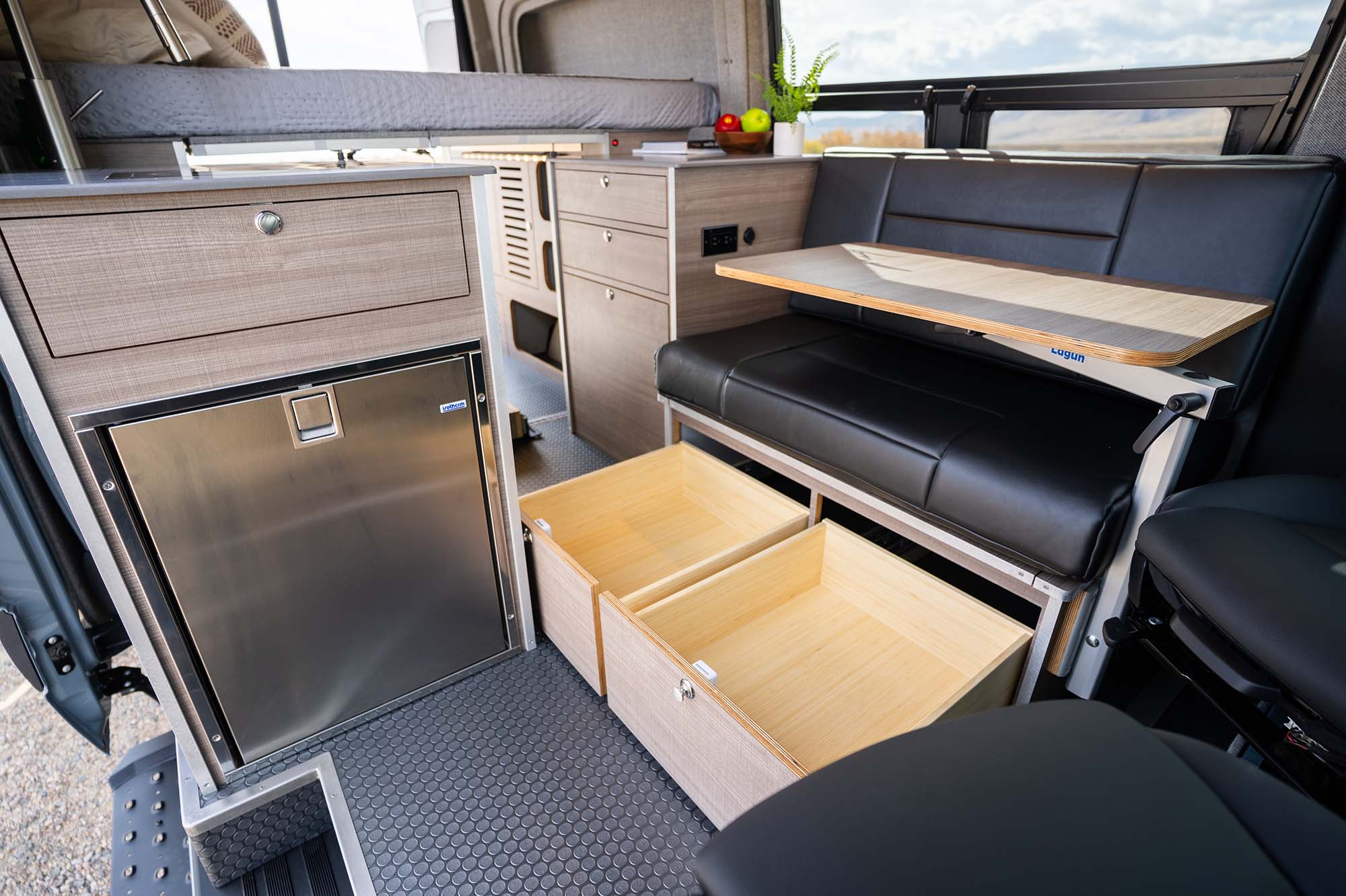 Drawers below the couch inside the living area of the Metis camper van