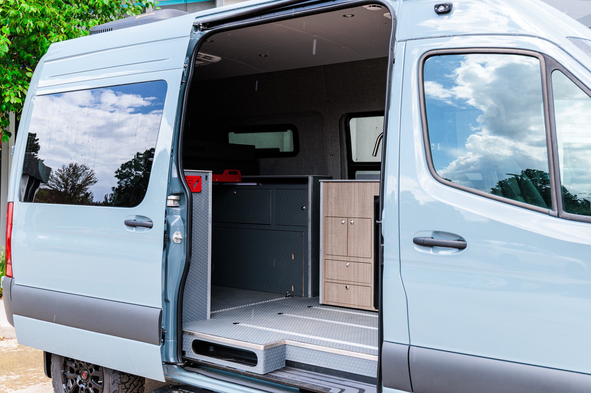 Blue Gray camper van with the slider door open on the elm laminate galley