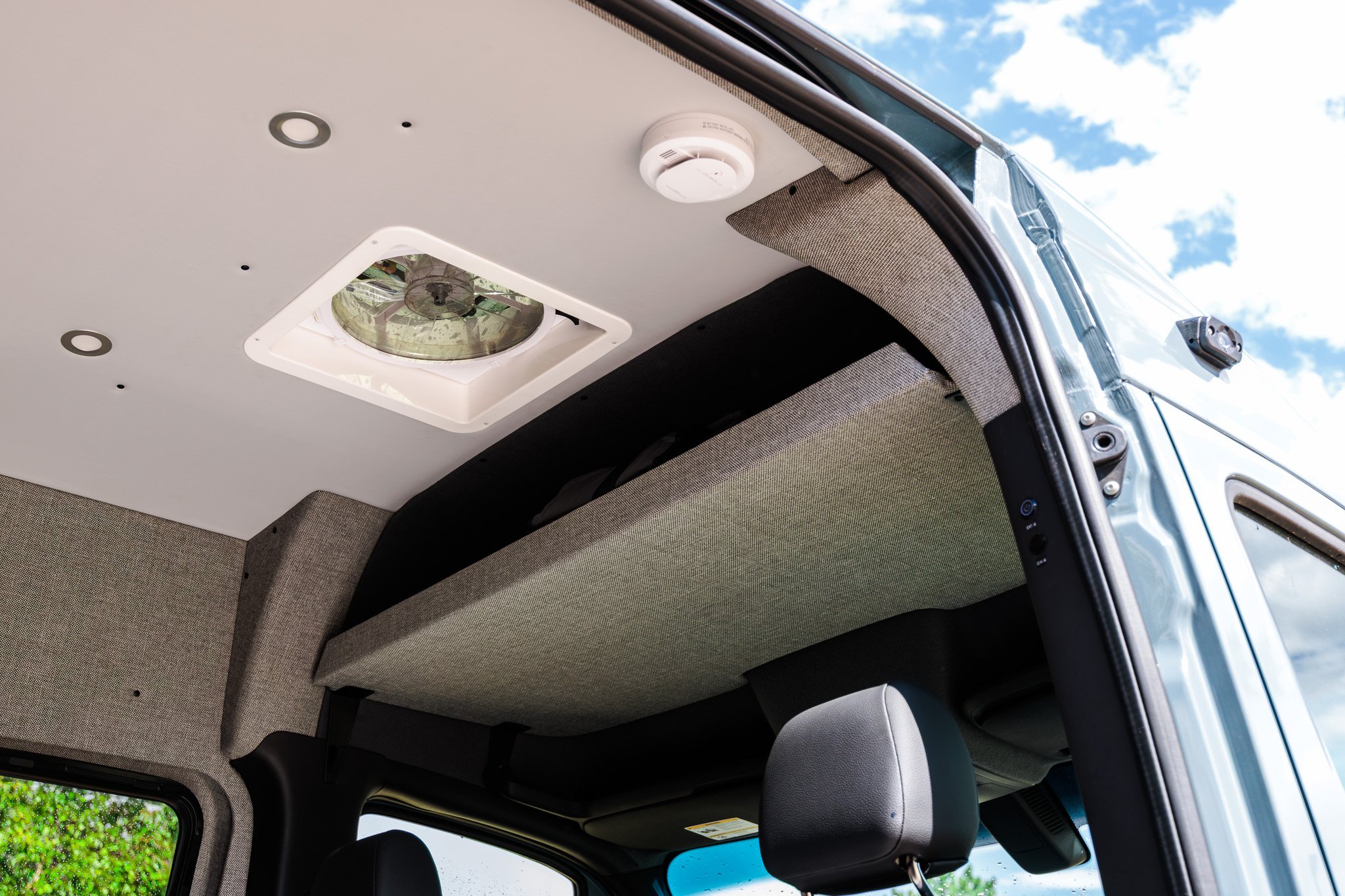 Headliner shelf over the cab, with the rooftop fan and smoke alarm above it