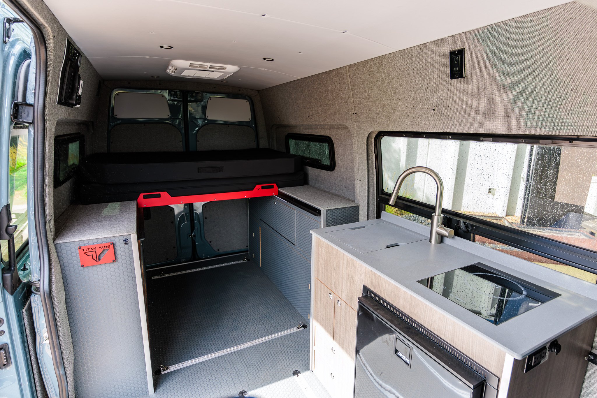 Classic 144 interior with the bed raised over the open adventure floor and the swivelled cab seats beyond