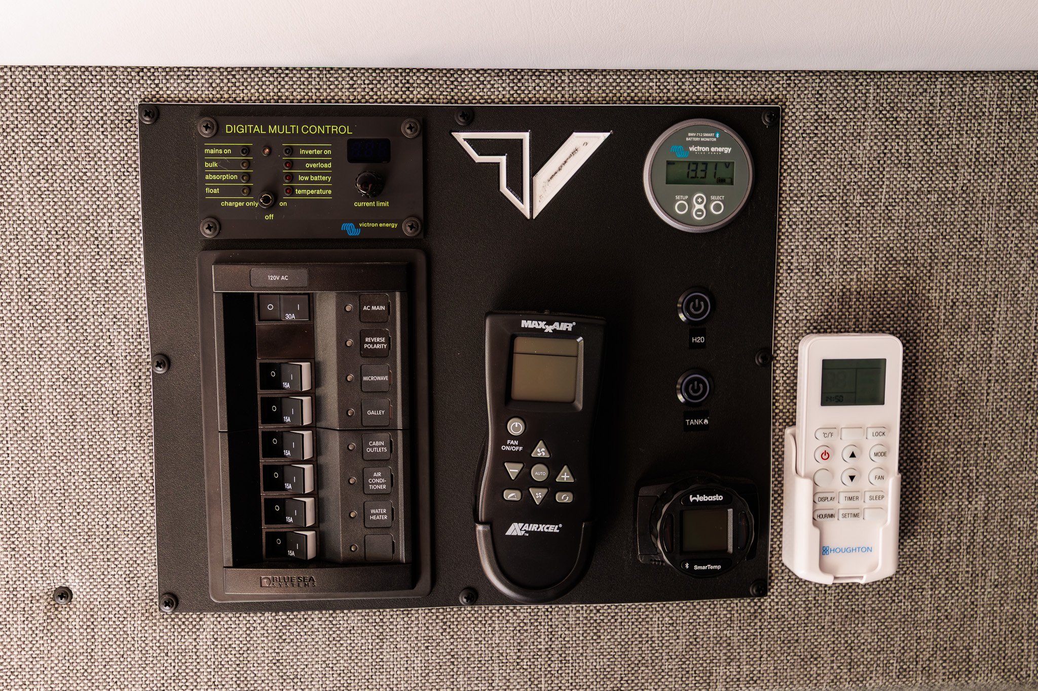 Control panel — Victron digital multi control, 12V switch panel, battery monitor, rooftop fan and Webasto SmarTemp remotes