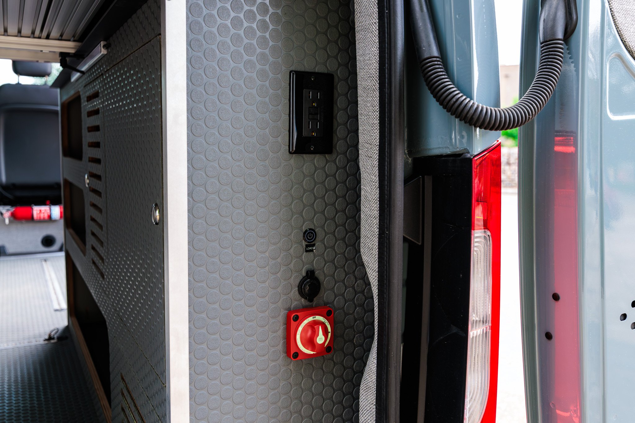 Rear door jamb with the battery disconnect, 12V socket and 120V exterior outlet