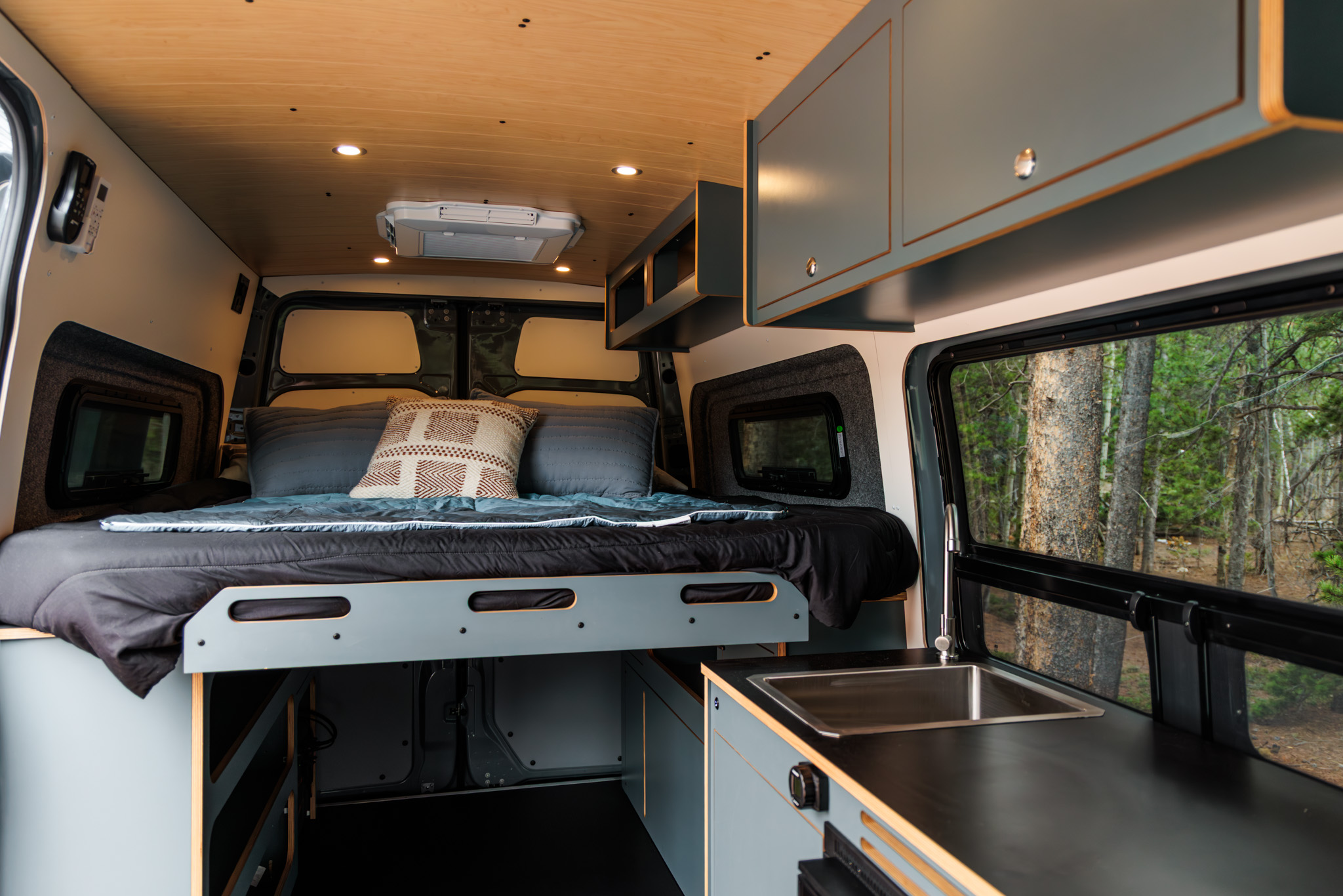 Bed made up at the rear, with the galley sink and the bunk window
