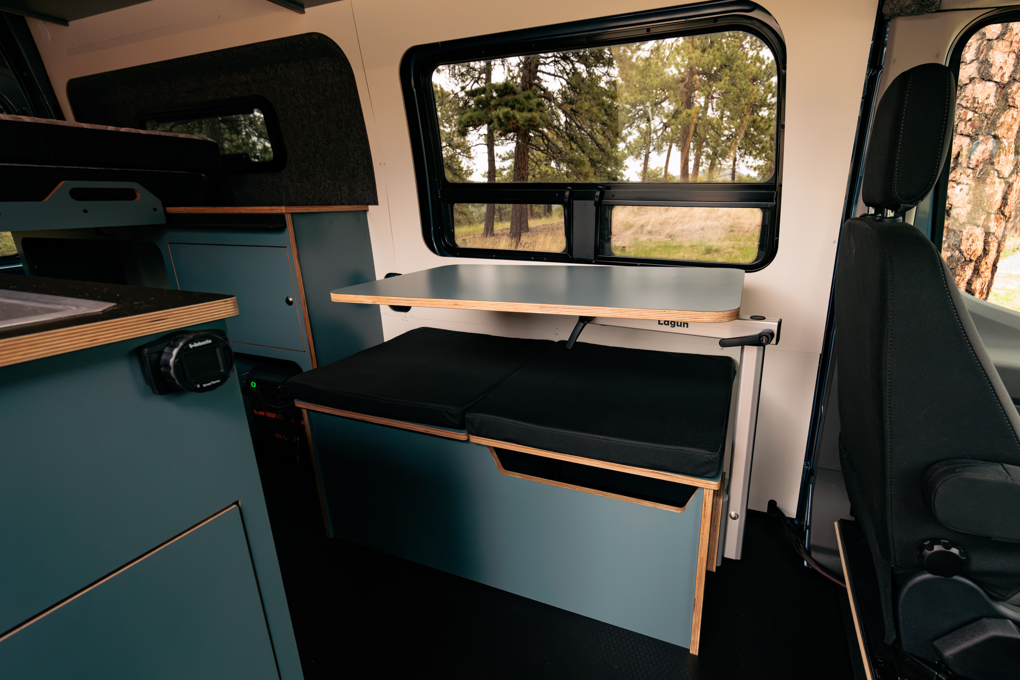 Lagun table and bench beside the side window, dark blue laminate cabinetry