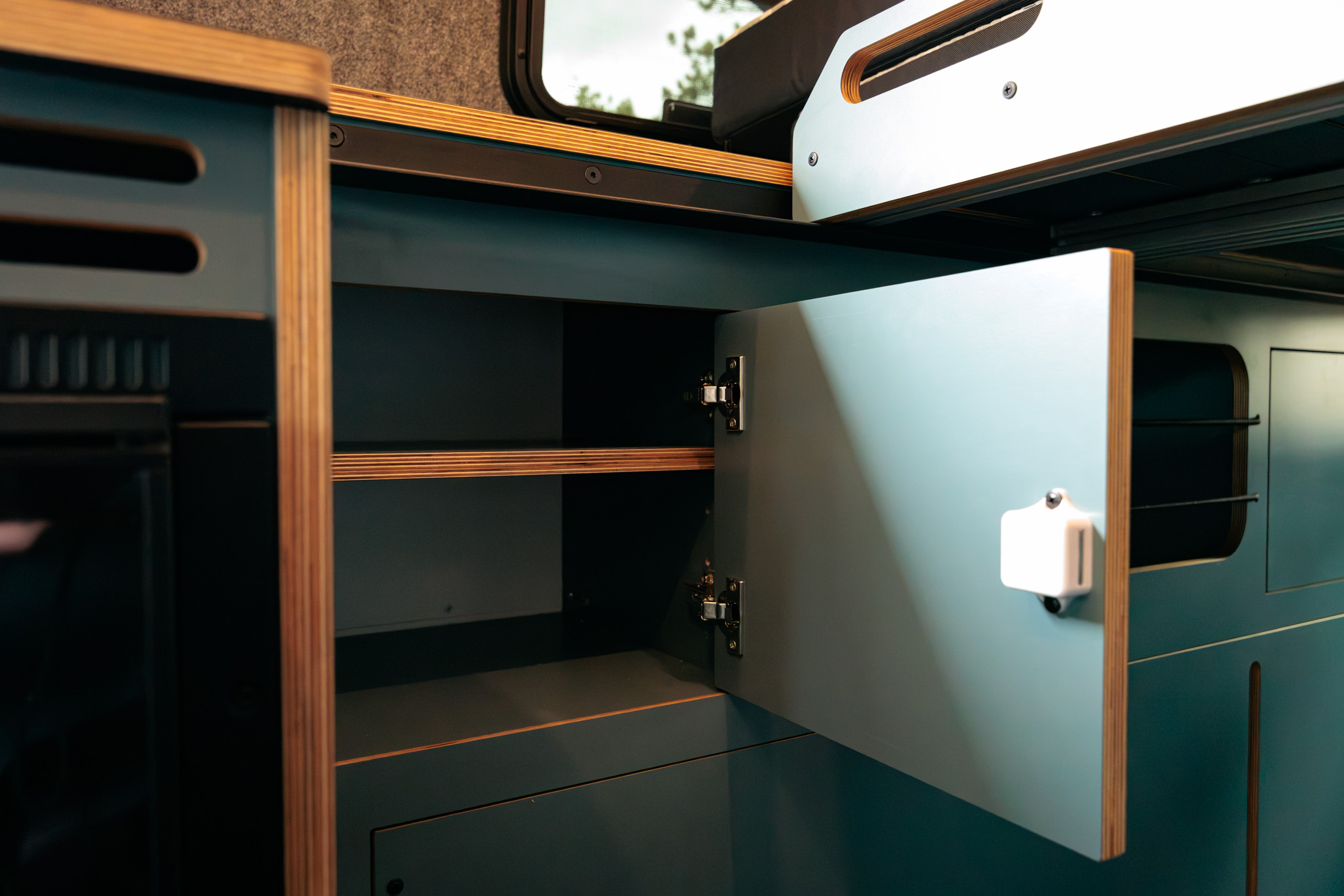 Dark blue laminate cabinet open, showing the shelf inside