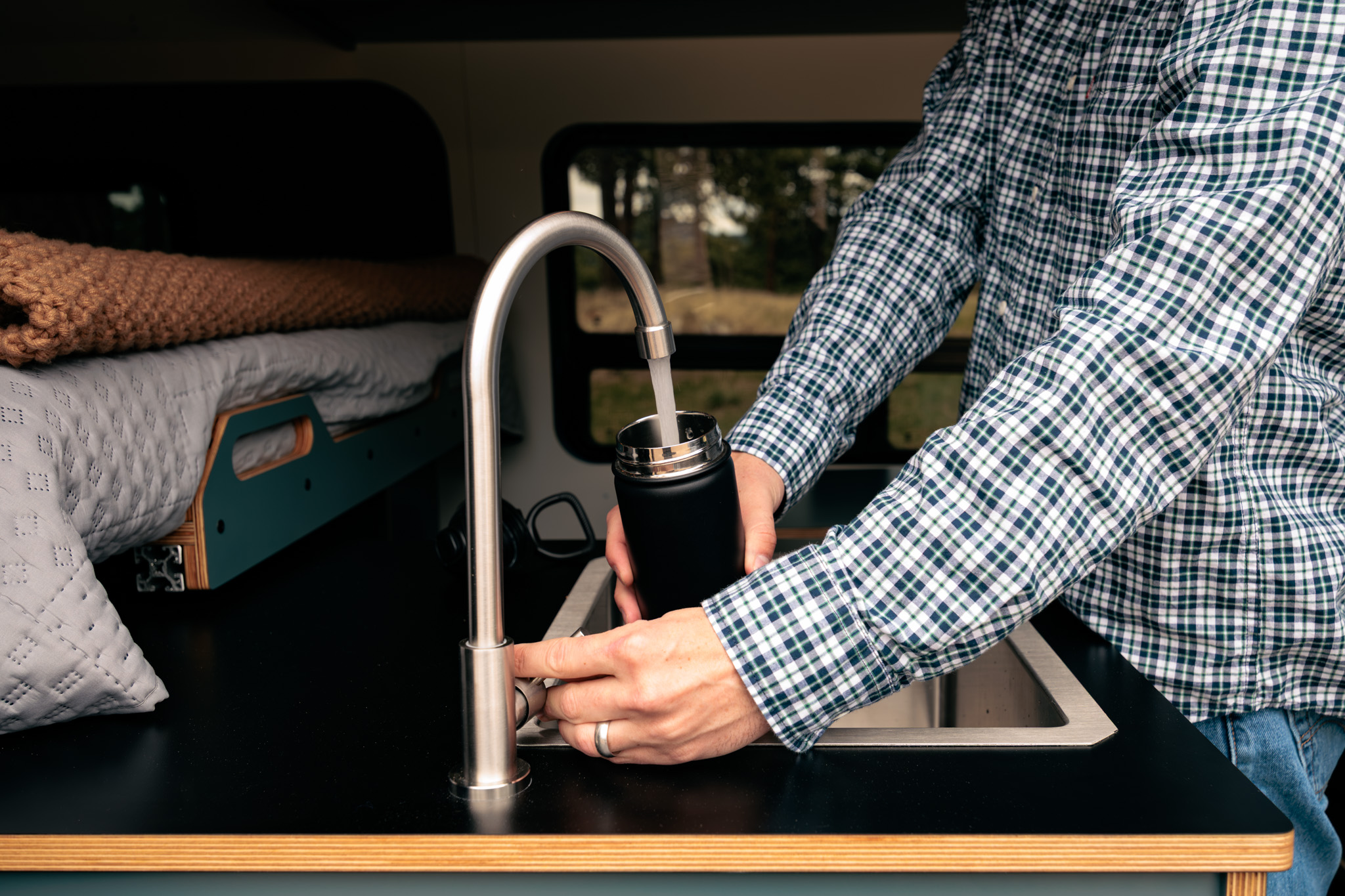 Filling a bottle at the galley faucet and stainless sink
