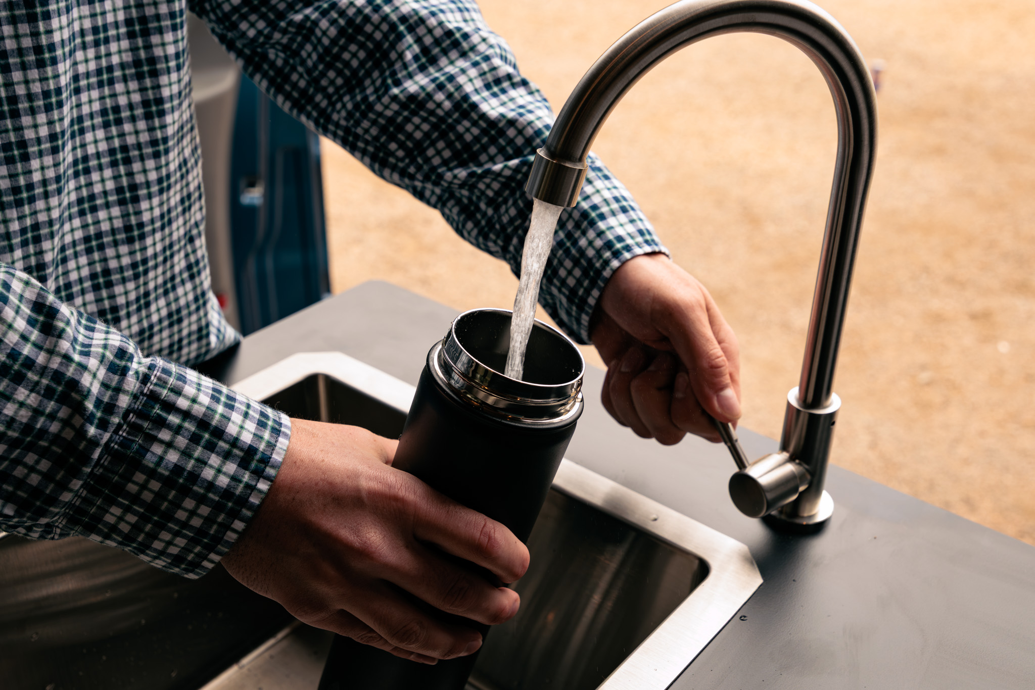 Galley faucet and stainless sink with the black countertop