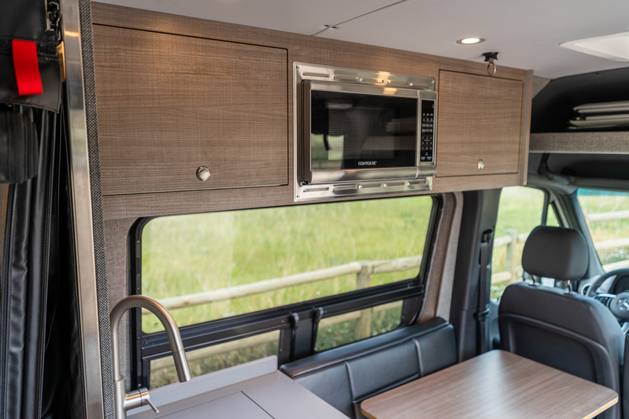 Camper van interior looking forward to the dinette and cab