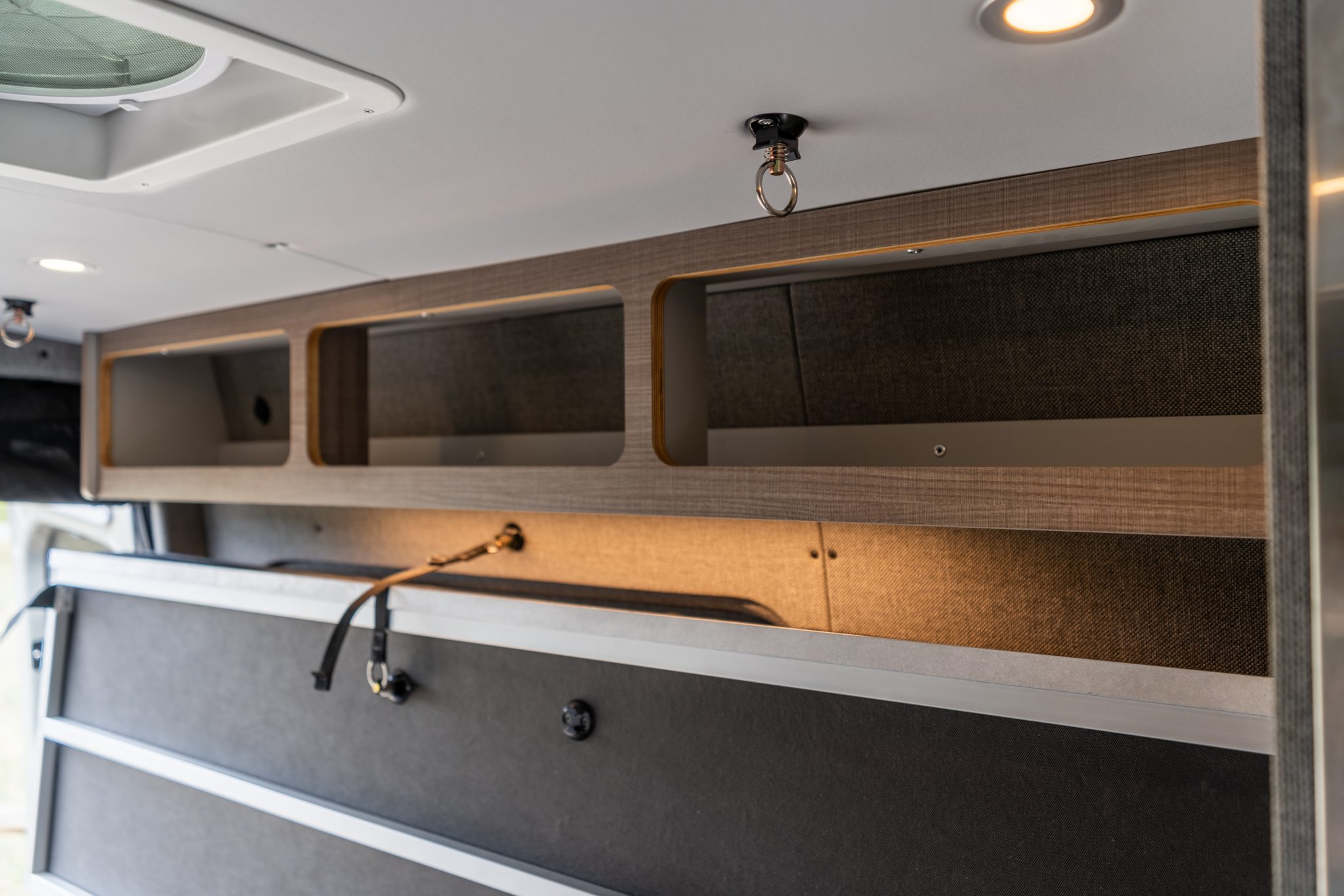 Camper van overhead cabinets and storage shelf