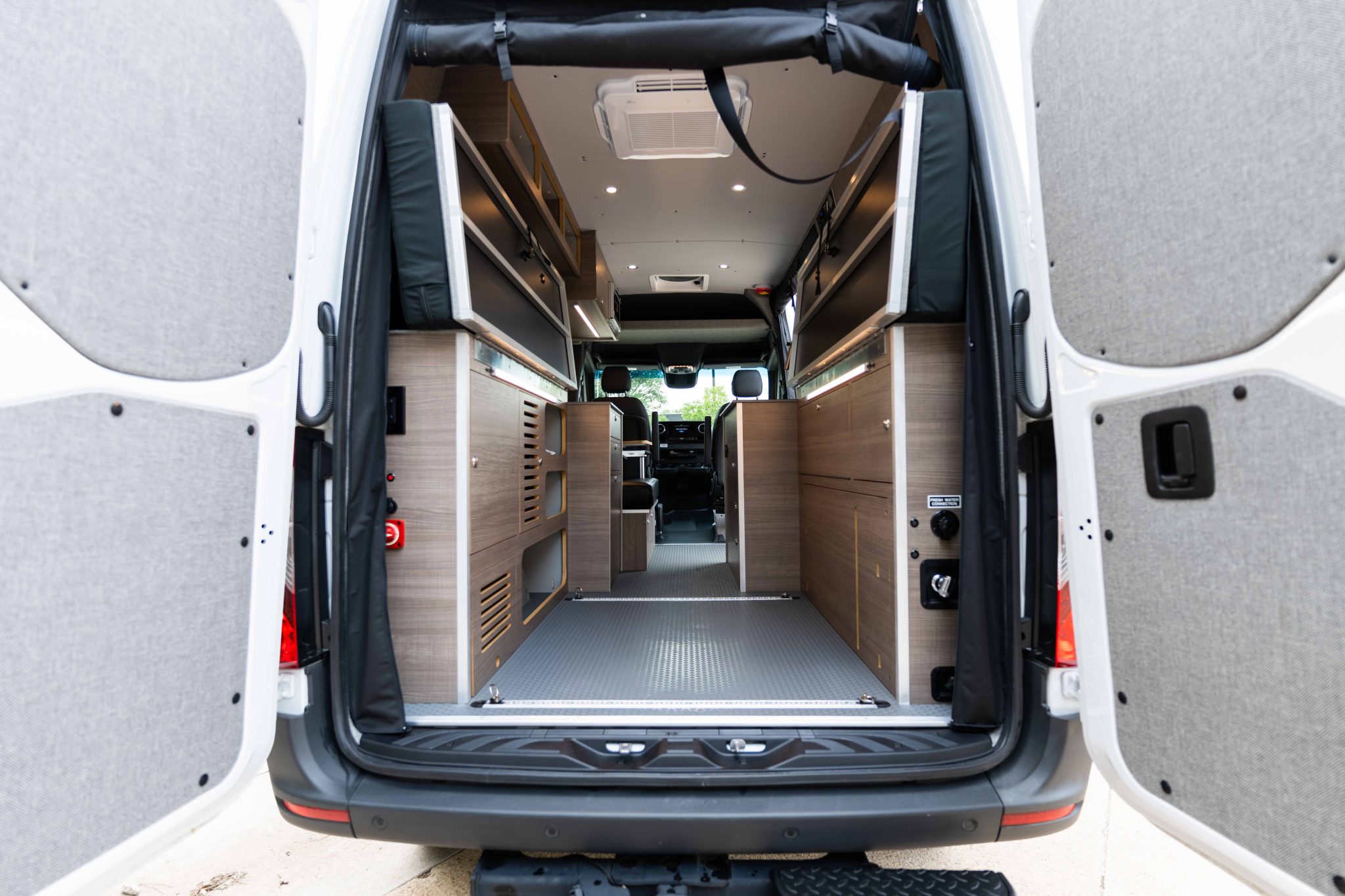 Rear doors open, looking forward through the van to the cab