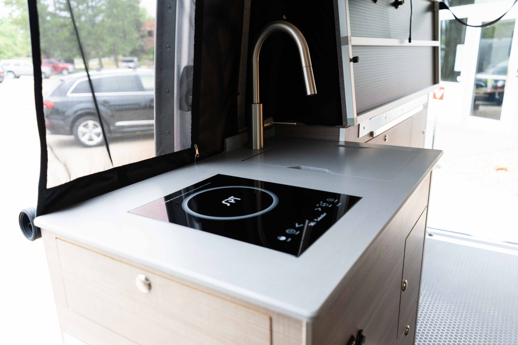 Galley counter with the induction cooktop, sink and the side-door bug net