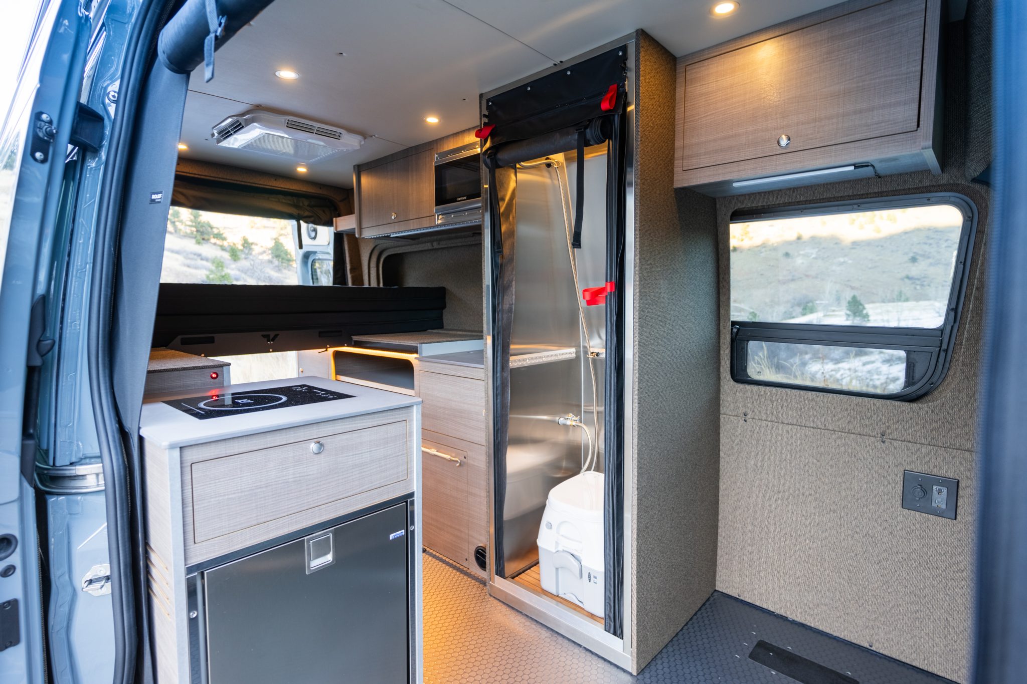Sliding door open on the galley, the shower and the overhead cabinets with the microwave