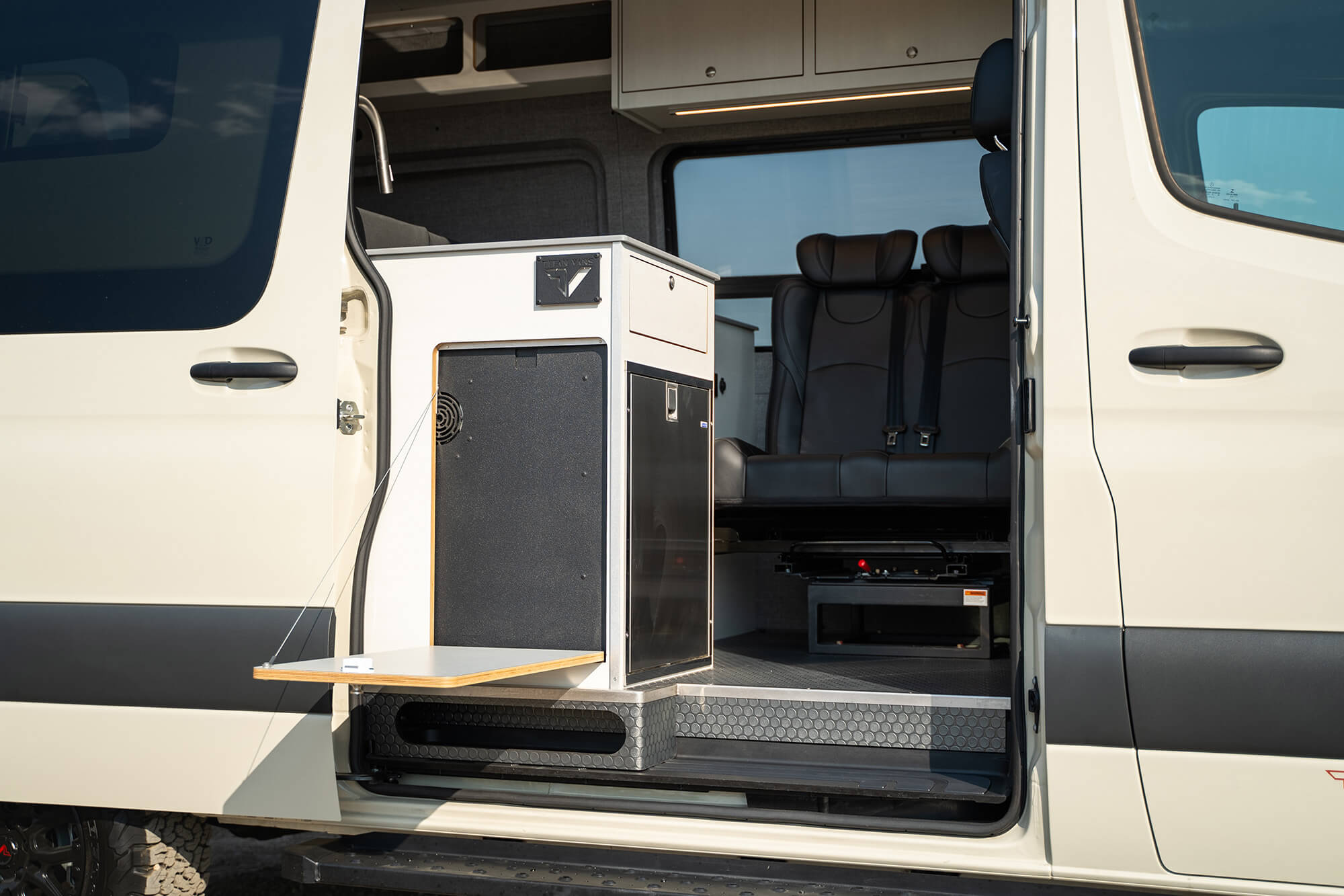 camper van sliding door open with with the kitchen galley with exterior fold-down table