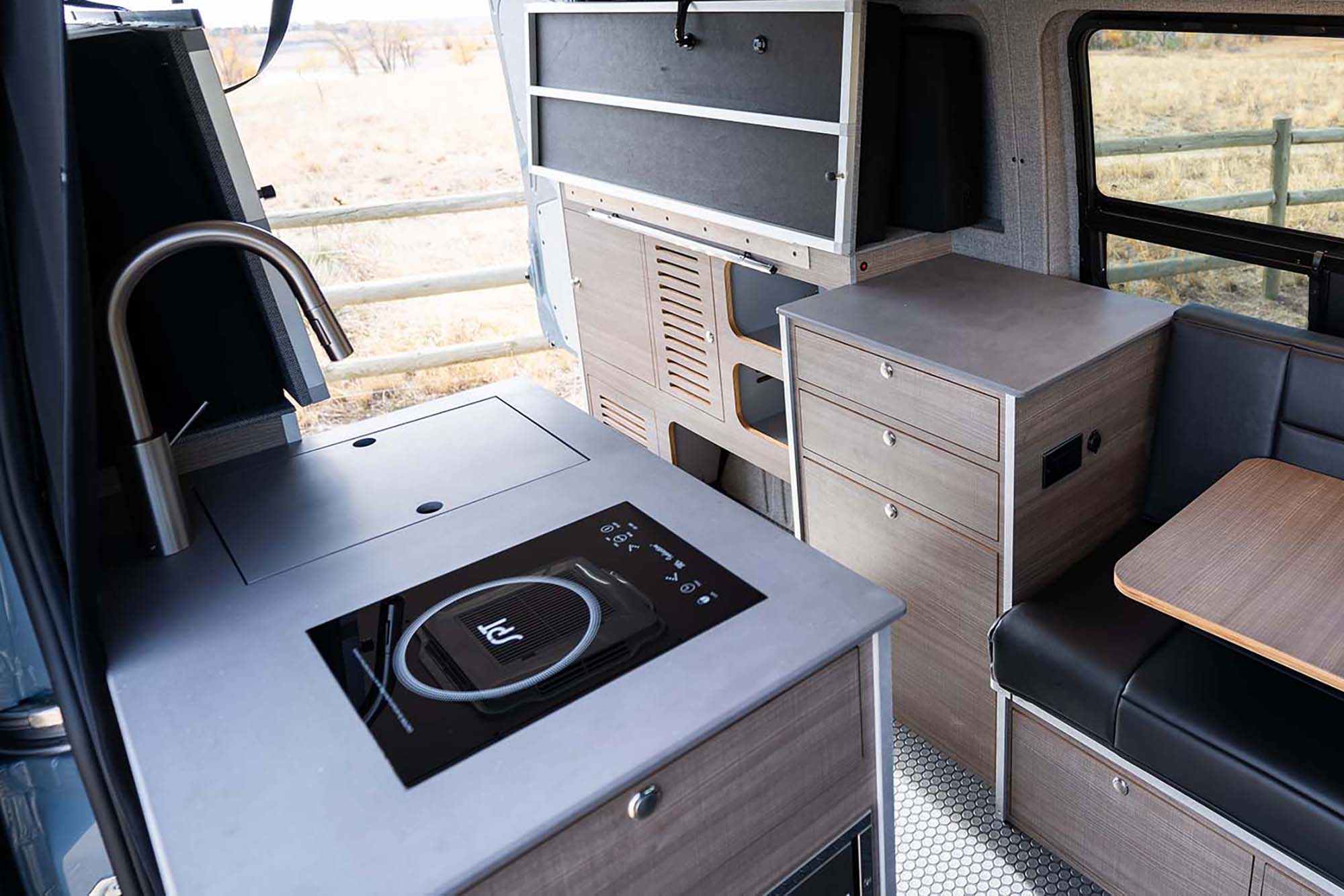 The double murphy bed and kitchen of the Metis camper van