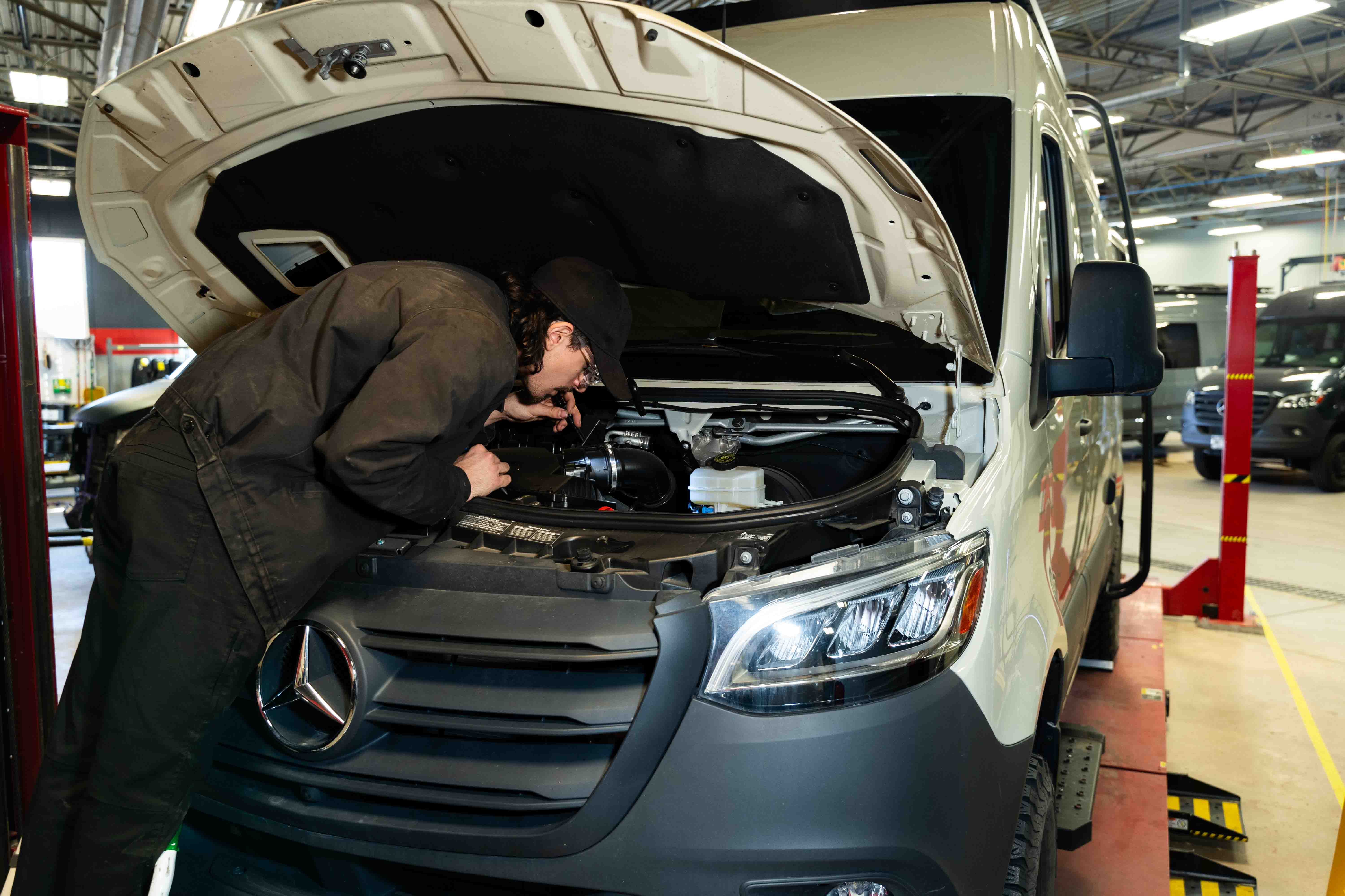 Titan Automotive Technician examining the engine bay of a Mercedes Sprinter